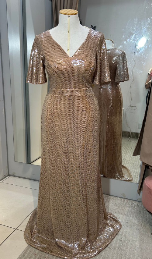 Detalhe do vestido dourado de festa com decote V e brilho intenso